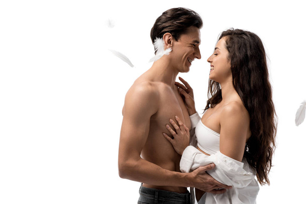 веселая пара обнимается и веселится с перьями, изолированными на белом
 - Фото, изображение
