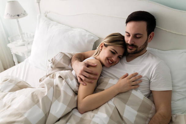 Jonge aantrekkelijke gelukkige paar met romantische tijd in bed - Foto, afbeelding