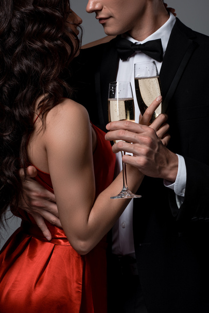 vue recadrée du couple romantique serrant et tenant des verres à champagne, isolé sur gris
 - Photo, image