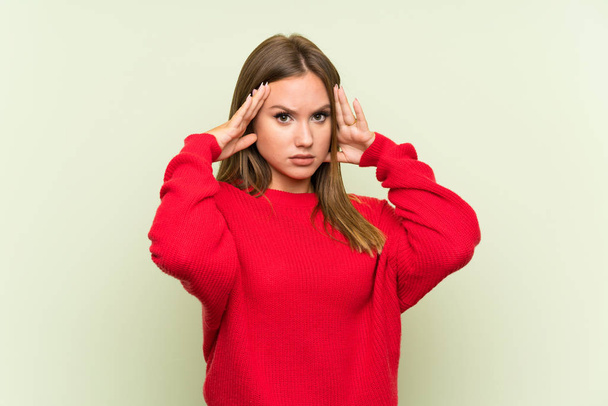 Teenager girl over isolated green background unhappy and frustrated with something. Negative facial expression - Photo, Image