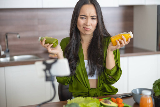 Annoyed housewife holding two bottles of sauces - Photo, Image