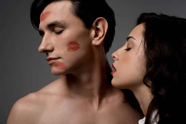 sensual woman and man with red lipstick prints, isolated on grey - Фото, зображення