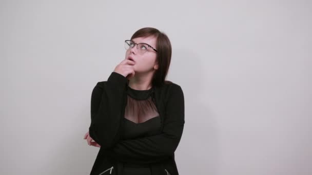 schönes junges Mädchen, denkend und schockiert, die Hand am Kinn, mit Brille - Filmmaterial, Video