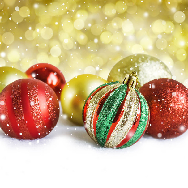 Χριστουγεννιάτικες χρυσές και κόκκινες μπάλες, σε λευκό και χρυσό bokeh defo - Φωτογραφία, εικόνα