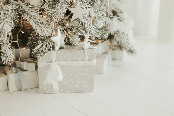 gray box with present under christmas tree. Presents and Gifts under Christmas Tree, Winter Holiday Concept - Фото, изображение