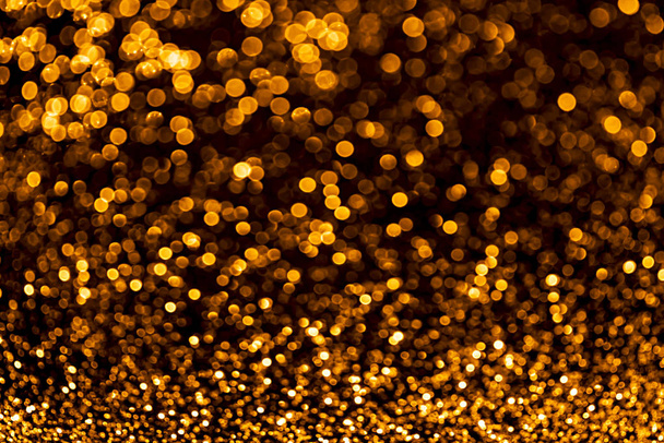 Golden sparkles raster festive background. Bokeh lights with bright shiny effect illustration. Overlapping glowing and twinkling spots decorative backdrop. Abstract glittering circles. - 写真・画像