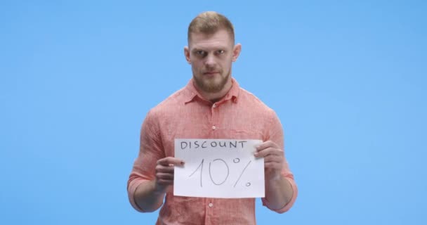 Young man holding discount sign - Footage, Video