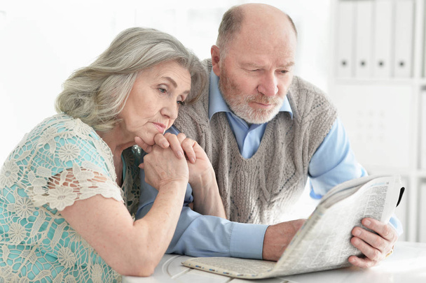 Close-up portrait of a  senior couple with newspaper  at home  - Fotografie, Obrázek