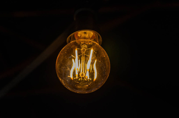 Incandescent light bulb illuminates the dark - Φωτογραφία, εικόνα
