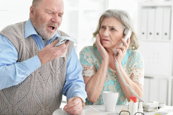 ill Senior couple with pills at home calling doctor - Foto, imagen