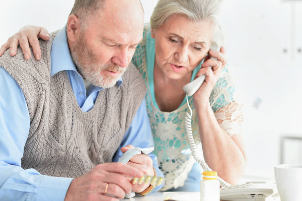 ill Senior couple with pills at home calling doctor - Φωτογραφία, εικόνα