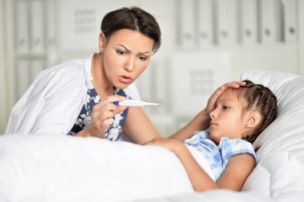sad woman with daughter in hospital ward - Foto, Bild