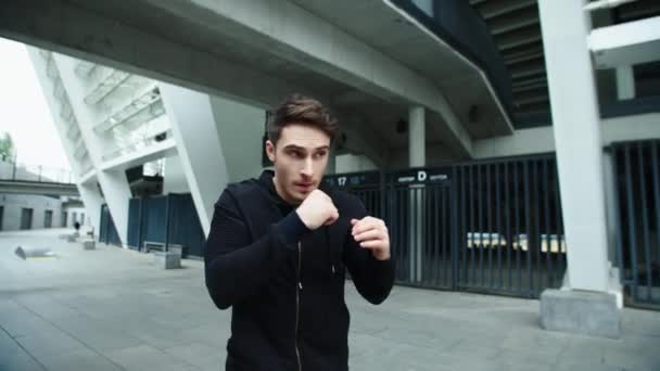 Wojownik trenuje boks na miejskiej ulicy. zbliżenie człowiek boks zewnątrz - Materiał filmowy, wideo
