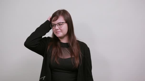 Mujer atractiva mirando frustrado y toma de la mano en la cabeza, sobre la pared gris
 - Metraje, vídeo