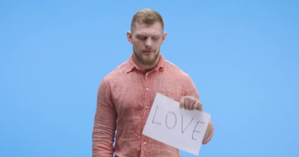 Man holding up love sign - Filmati, video