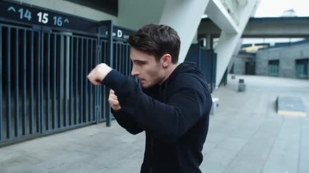 Νεαρός πυγμάχος σε αστικό δρόμο. Πορτρέτο του kickboxer προπόνηση γροθιά - Πλάνα, βίντεο