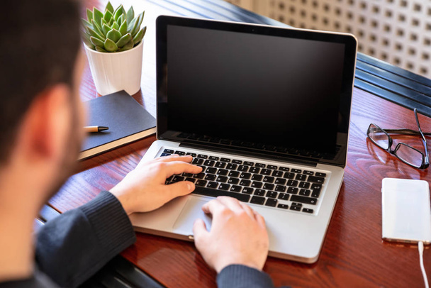Φορητός υπολογιστής με μαύρη λευκή οθόνη σε ξύλινο γραφείο - Φωτογραφία, εικόνα