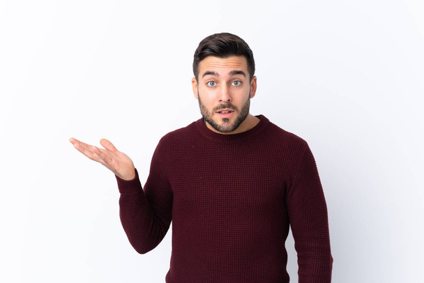 Young handsome man with beard over isolated white background making doubts gesture - Photo, Image
