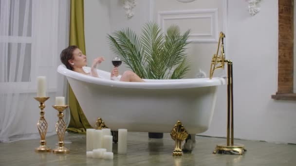 Kobieta, picia wina w kąpieli. - Materiał filmowy, wideo