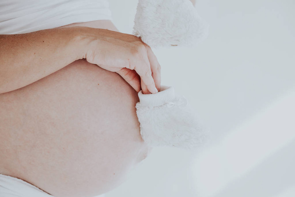 шлунок вагітної жінки і дитячі шкарпетки 1
 - Фото, зображення
