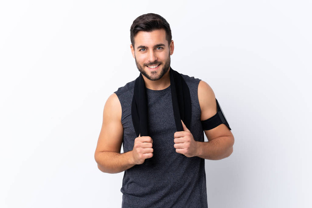 Young sport handsome man with beard over isolated white background with sport towel - Foto, afbeelding