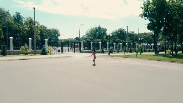 Little girl rolls on skates - Materiał filmowy, wideo