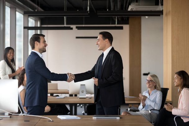 Executive manager schudden hand van succesvolle werknemer op vergadering - Foto, afbeelding
