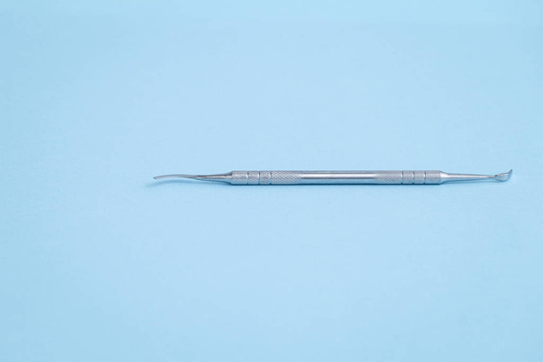 Stainless dental probe laying on light blue background - Photo, Image