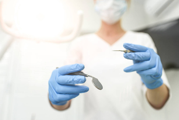 Closeup of dental instruments in hands of doctor. Selective focus - Foto, Bild