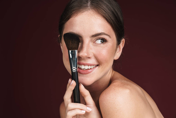 Image of joyful half-naked woman using makeup brush - Zdjęcie, obraz