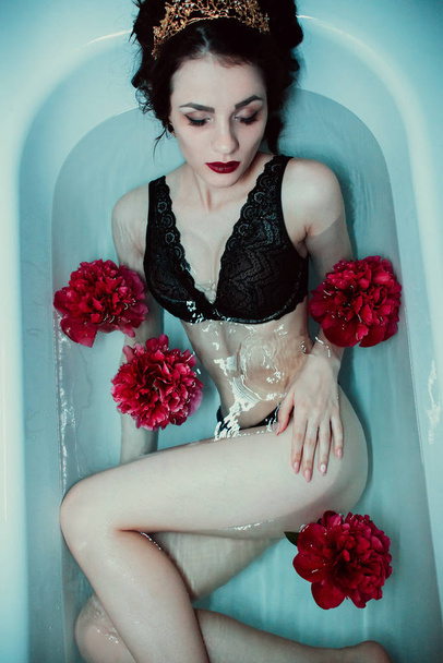 girl in lingerie enjoys in bath with peonies - 写真・画像