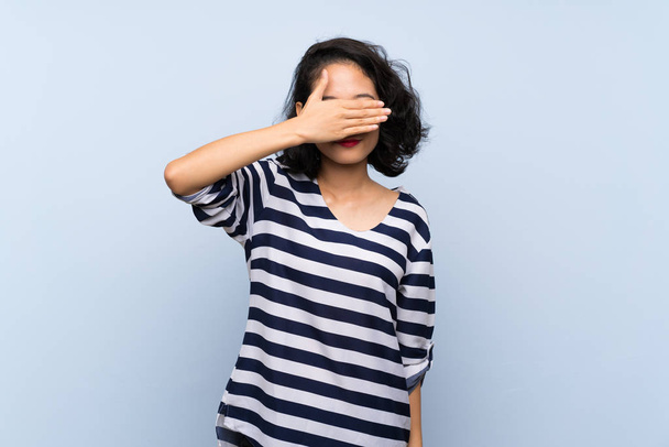 Asiatica giovane donna su sfondo blu isolato che copre gli occhi a mano. Non voglio vedere qualcosa.
 - Foto, immagini
