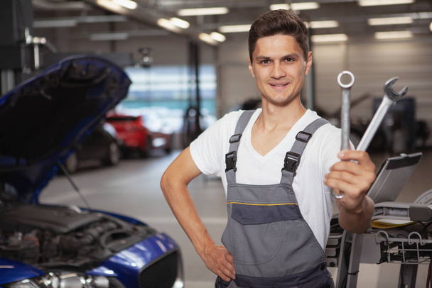 Jeune beau mécanicien automobile réparant véhicule dans son garage
 - Photo, image