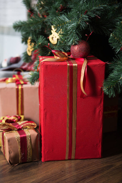 Kaunis joululahja laatikot lattialla lähellä joulukuusi seppeleitä ja joulun leluja
. - Valokuva, kuva
