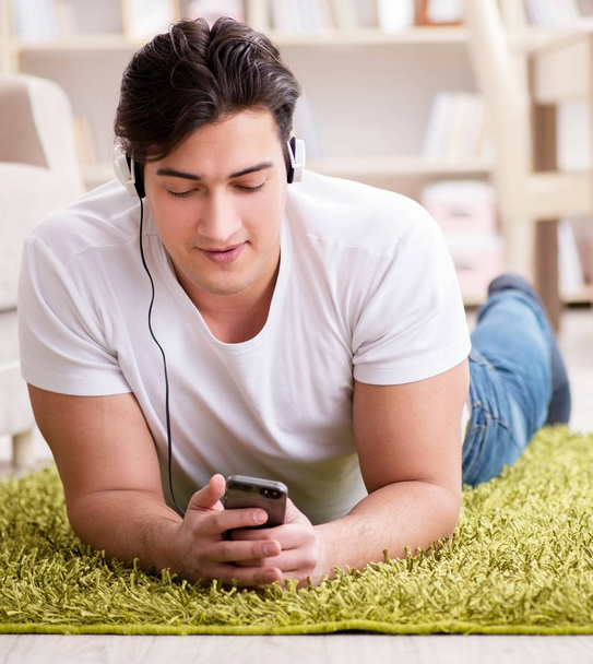Молодий студент слухає музику вдома
 - Фото, зображення