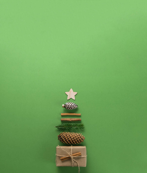 Christmas composition. Creative christmas background. Christmas decorations and gifts in the form of a Christmas tree against a green background. Flat lay, top view, copy space. - Valokuva, kuva