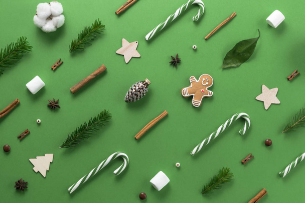 Christmas composition. Creative christmas background. Christmas decorations and fir branches create an ornament and texture on a green background. Flat lay, top view, copy space. - Фото, зображення