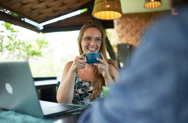 Молодая женщина тысячелетия держит кофейную кружку улыбаясь другу Дури
 - Фото, изображение