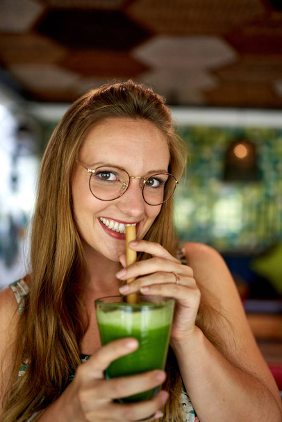 schöne junge Millennial Frau trinkt grünes Superfood glatt - Foto, Bild