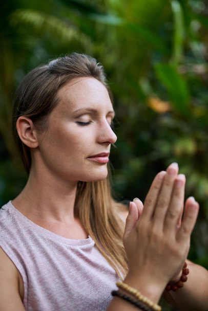 Attractive millennial woman alone in anjali mudra yoga position - Photo, Image