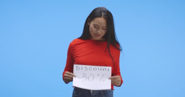 Jeune femme tenant signe de réduction
 - Séquence, vidéo