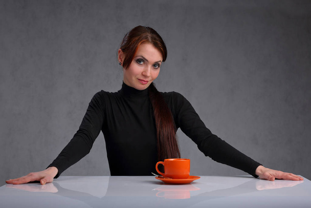 Una donna con una tazza di caffè arancione
 - Foto, immagini