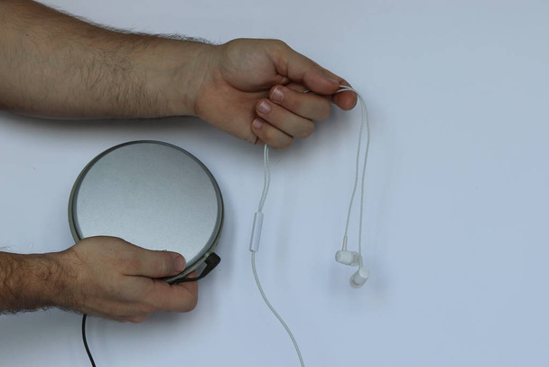 Mannen handen houden een draagbare cd-speler vast. Oude technologie. Witte hei - Foto, afbeelding