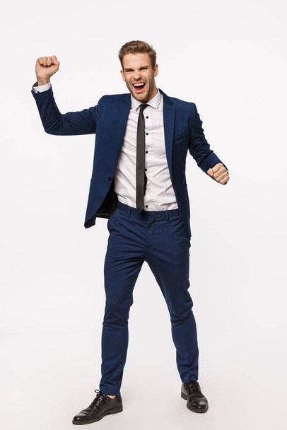 Vertical full-length shot excited, rejoicing cheerful businessman in classic suit, raising hands up, fist pump celebrating victory, become champion, made good deal, signed contract, white background - Fotó, kép