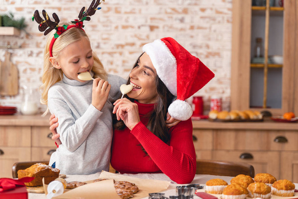 Family enjoying Christmas candy in the kitchen - Photo, image