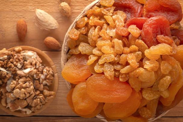 Sekoita kuivattuja hedelmiä, pähkinöitä ja siemeniä puupöydällä. Lähemmäs. Yläkuva
 - Valokuva, kuva