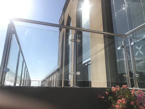 An Stainless steel glass transparent handrails with hairline finish fixed at lobby or entrance of multistory buildings and sky background visible with white clouds - Photo, Image