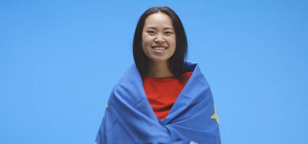 Jovem envolta e a dançar com a bandeira da UE
 - Foto, Imagem