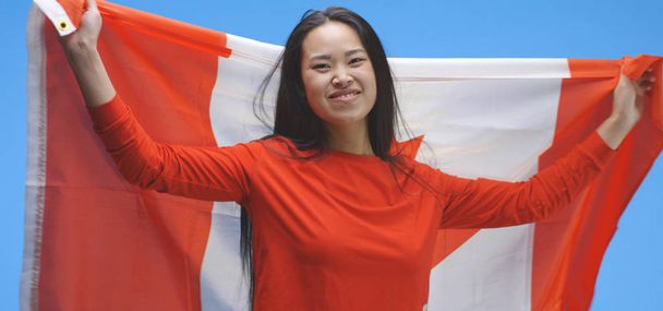Νεαρή γυναίκα τυλιγμένη και χορεύοντας με καναδική σημαία - Φωτογραφία, εικόνα