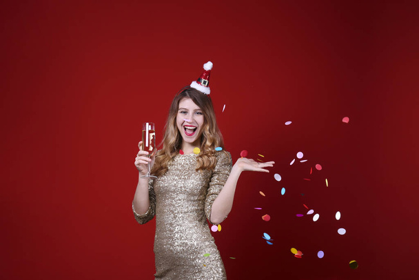 Smiling woman wearing celebratory outfit on red wall background. - Fotografie, Obrázek